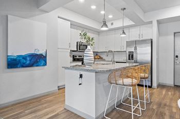 A kitchen with an island and a bar with stools